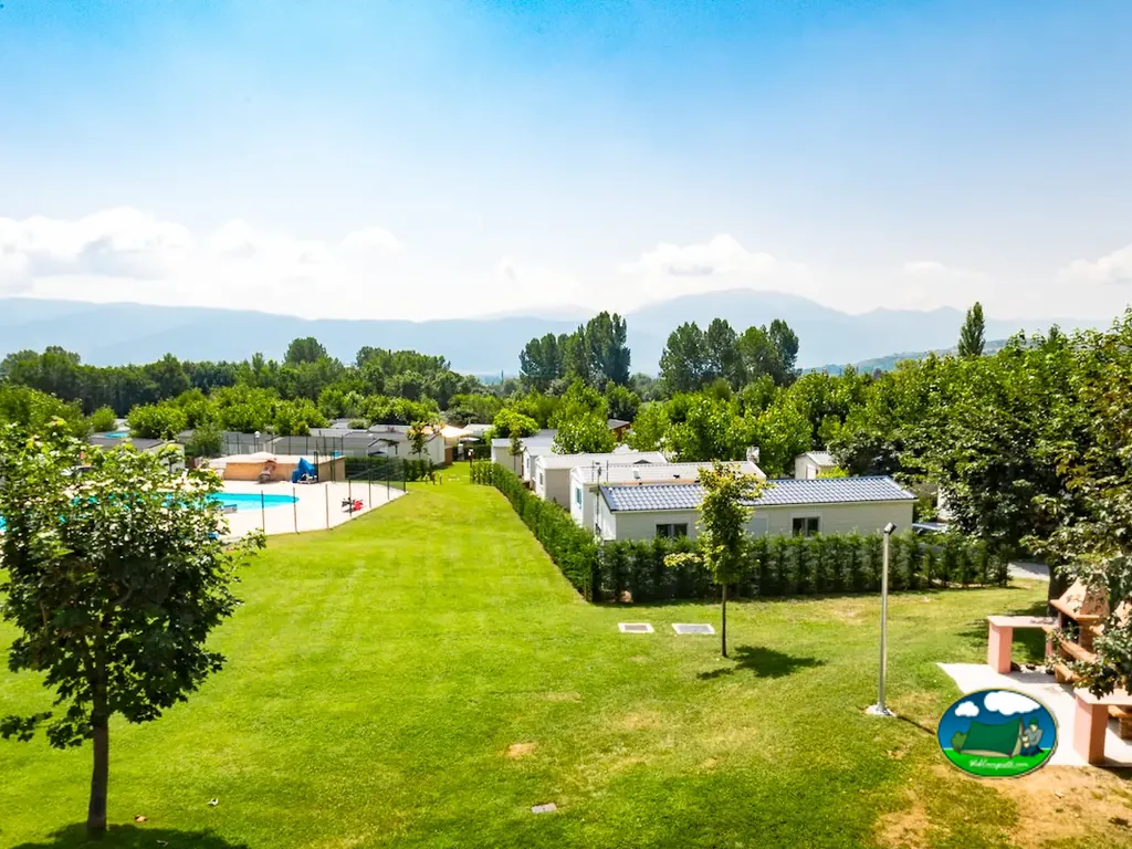 vista aérea del camping con piscina, mobil-homes y jardines en Enveitg
