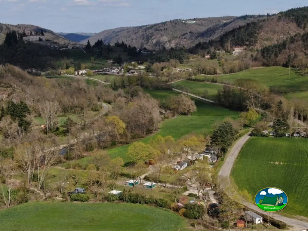 vista aérea del valle con el camping junto al río entre colinas boscosas en Boucieu-le-Roi