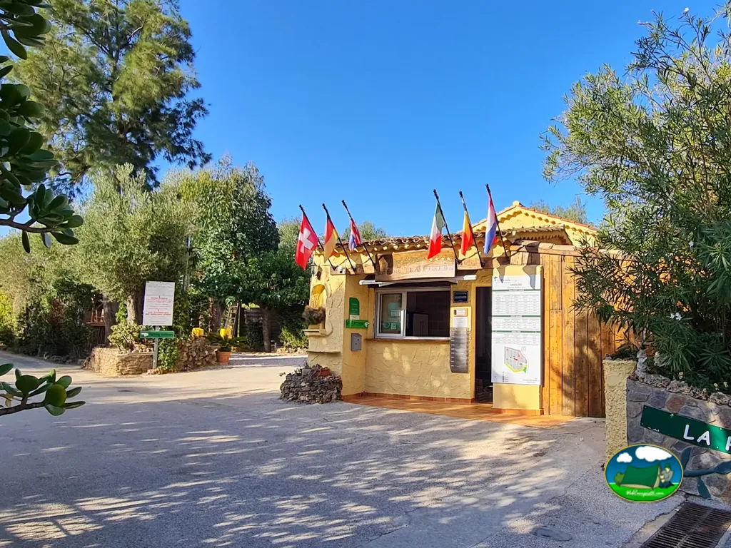 caseta de recepción del camping con banderas de varios países junto a la entrada en Cavalaire-sur-Mer