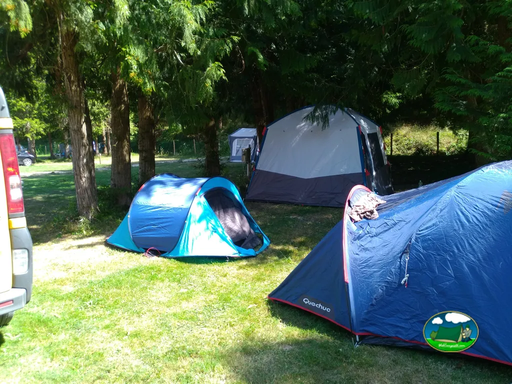 tiendas de campaña instaladas bajo árboles junto a una furgoneta en Saint-Mandé-sur-Brédoire