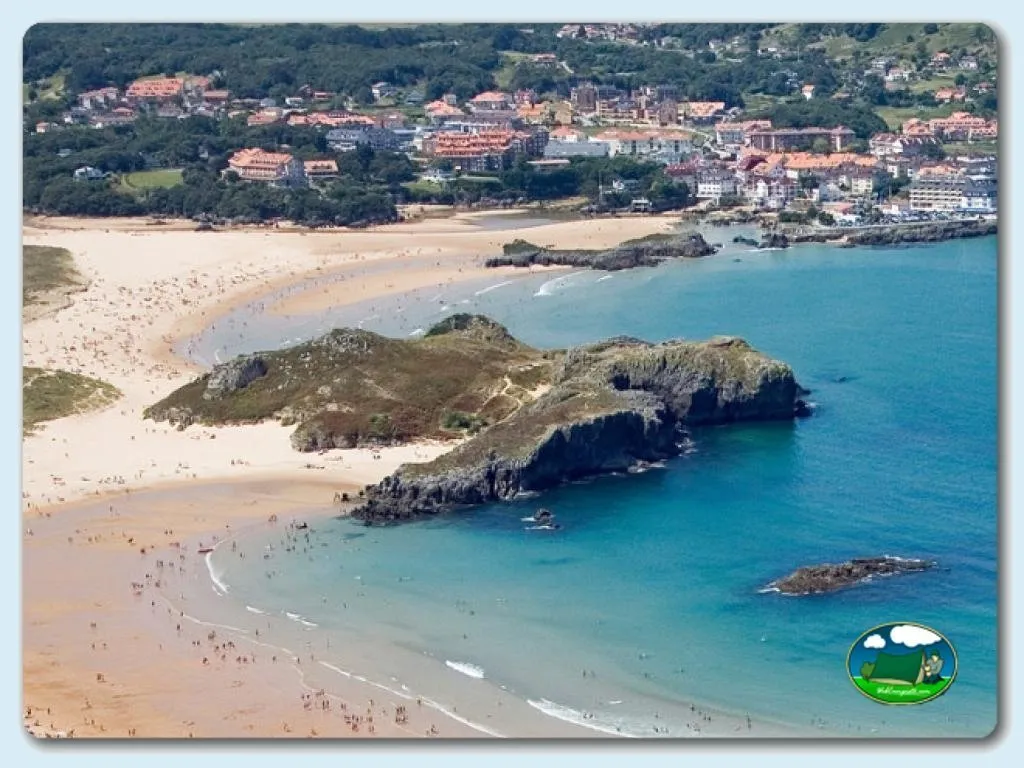 Playa junto al mar con vistas a la montaña y pueblo costero del Camping Playa de Ris, Noja (Cantabria)