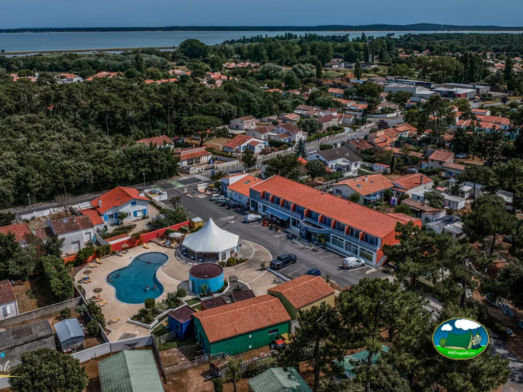 vista aérea del camping con piscina y edificio de recepción junto al pueblo y la bahía en Saint-Trojan-les-Bains