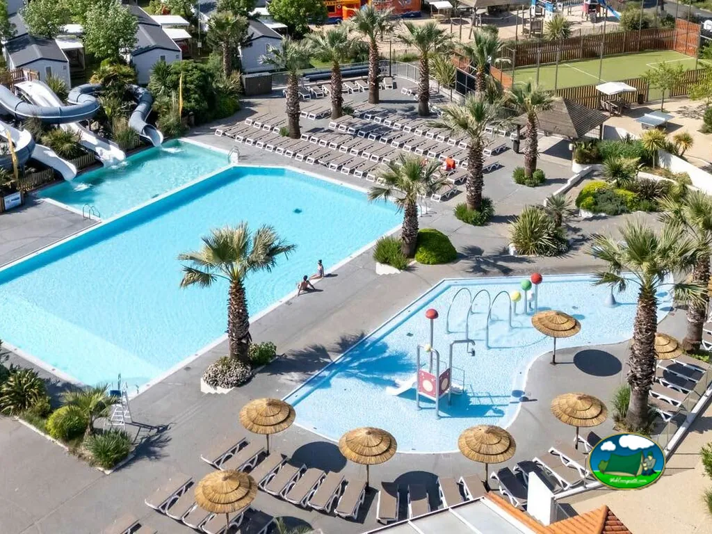 vista aérea de piscinas con toboganes, zona infantil y mobil-homes entre palmeras en Talmont-Saint-Hilaire