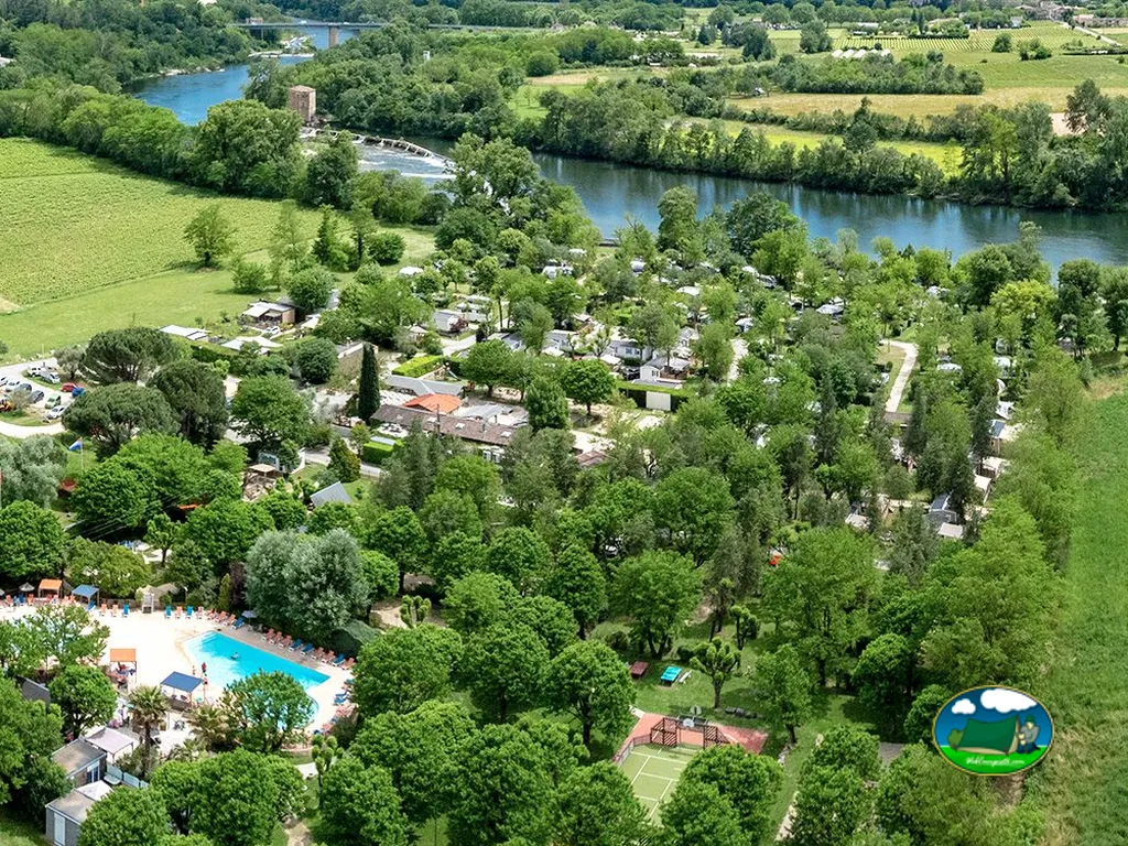 vista aérea del camping arbolado junto al río con piscina y mobil-homes en Vallon-Pont-d'Arc