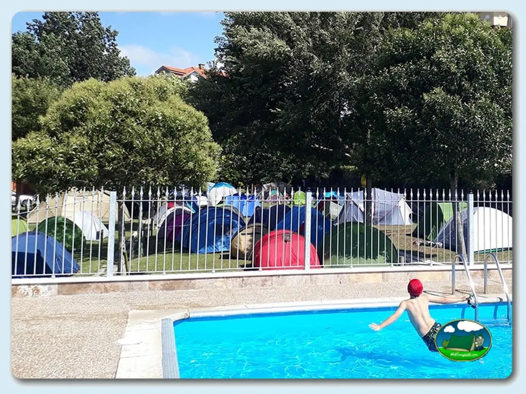 Piscina con niño en el agua y zona de tiendas de acampada del Camping Argos, Noja (Cantabria)