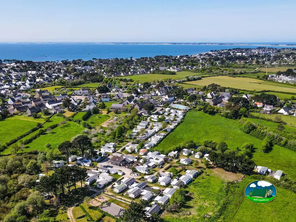 vista aérea del camping con filas de mobil-homes junto al mar y el pueblo en Carnac