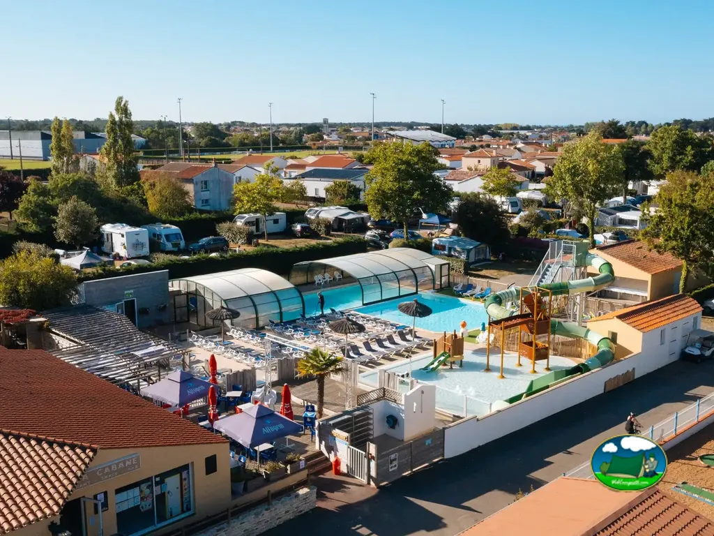 vista aérea del camping con piscina cubierta, parque acuático de toboganes y terraza de bar