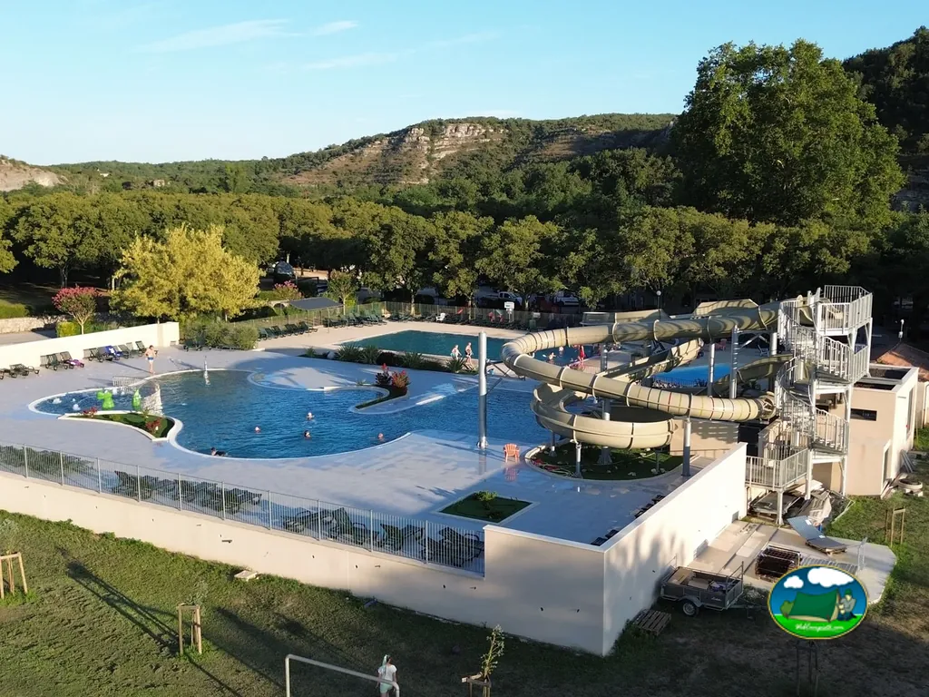 vista aérea de piscinas con toboganes acuáticos y bañistas en Rosières
