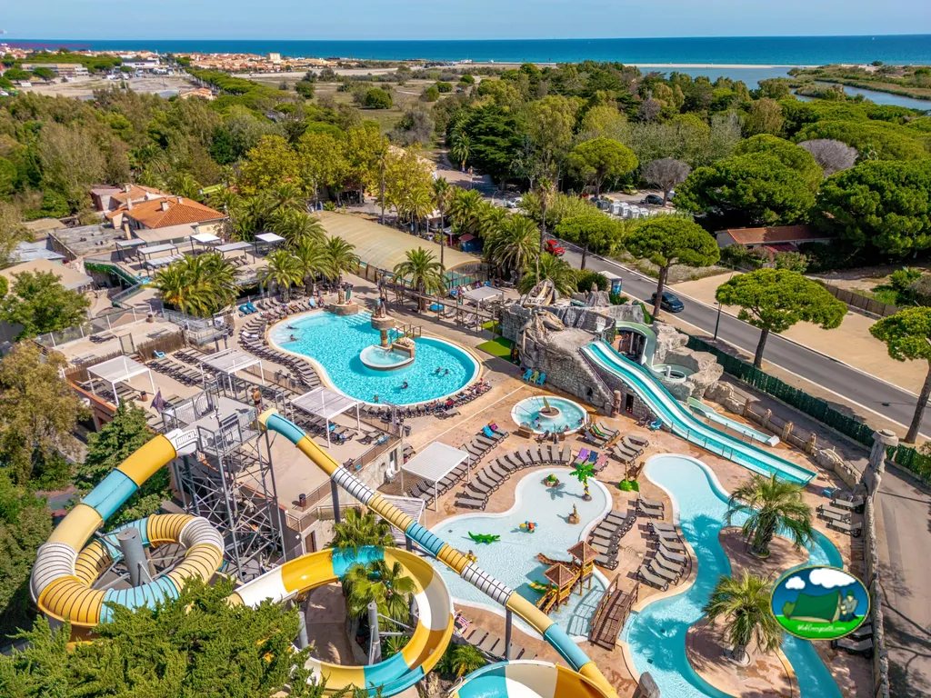 vista aérea del parque acuático con toboganes, piscinas y el mar al fondo en Le Barcarès