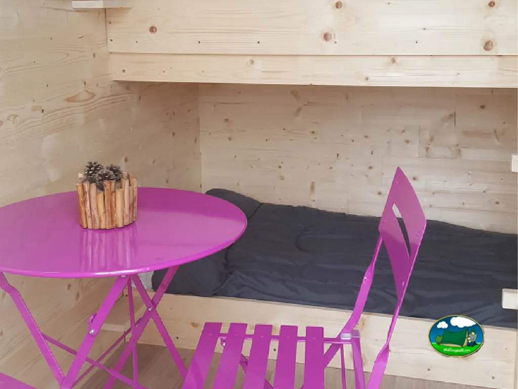 litera y mesa de color rosa en el interior de una cabaña de madera en Talmont-Saint-Hilaire