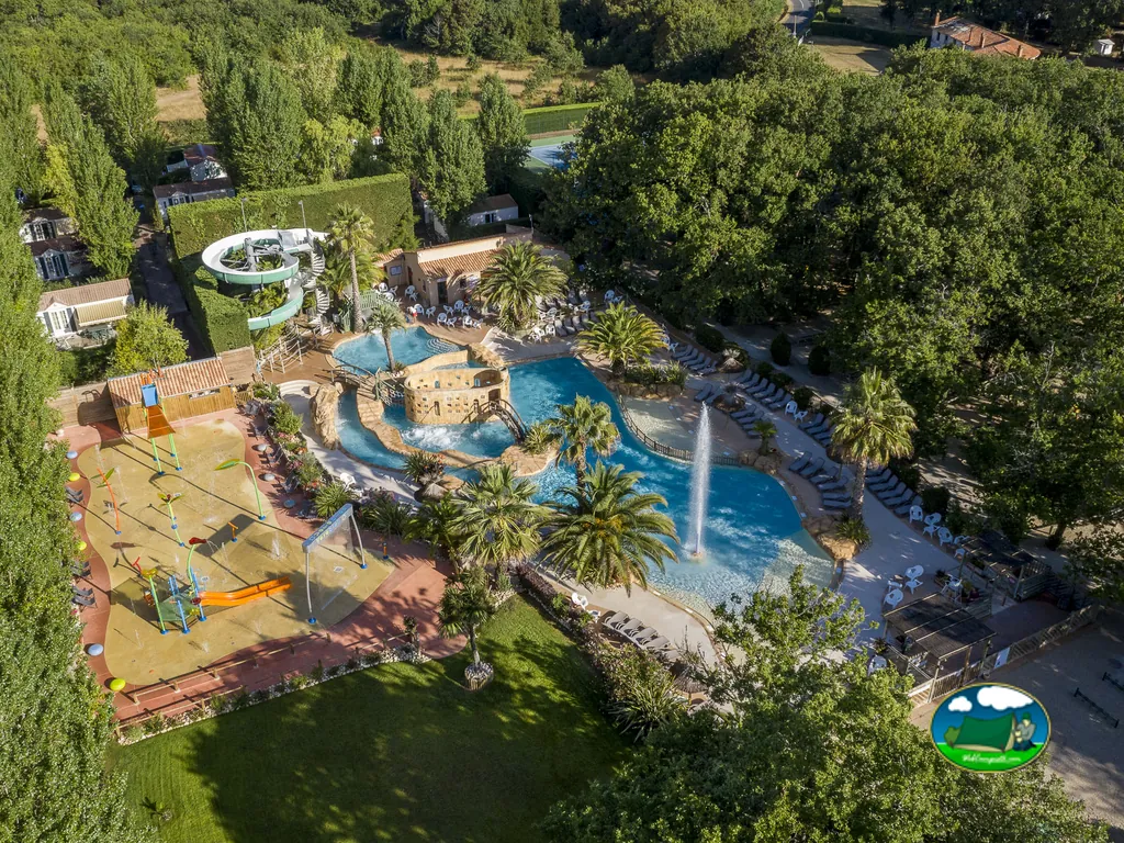 vista aérea de piscinas con río lento, fuente y zona de juegos acuáticos rodeada de árboles en Saint-Georges-d'Oléron