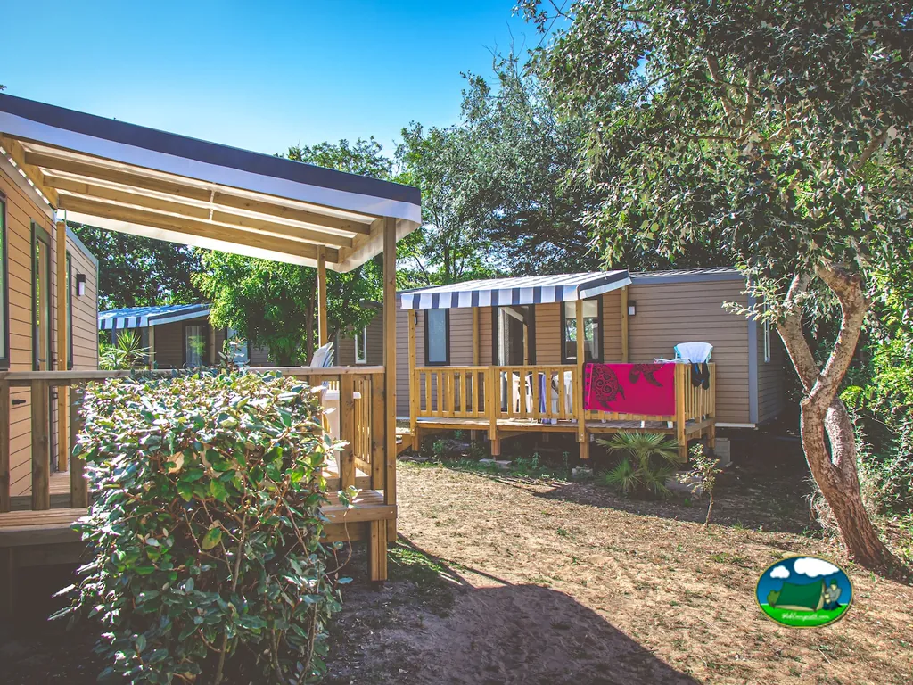 mobil-homes con terraza de madera entre árboles en el camping de Saint-Georges-d'Oléron