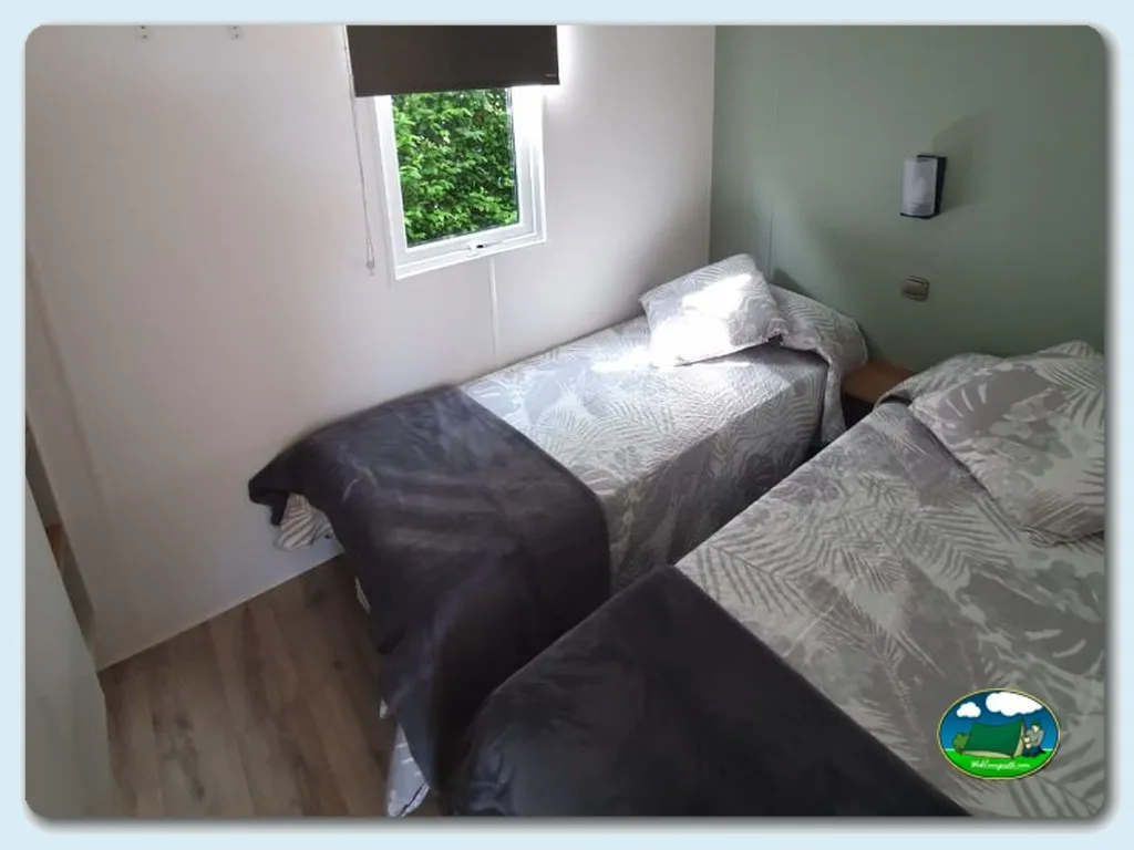 Mobil-home interior con camas y ventana del Camping Sopelana, Sopelana (Vizcaya)