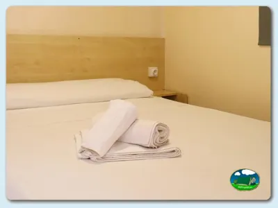 Interior mobil-home con camas y toallas del Camping Los Escullos, Almería (Almería)