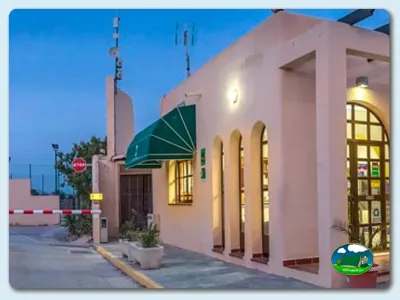 Recepción moderna con arquitectura rosa y iluminación nocturna del Camping Los Escullos, Almería (Almería)