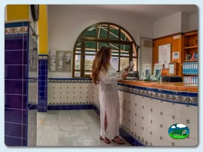 Recepción con mostrador y ventana circular del Camping Los Escullos, Almería (Almería)