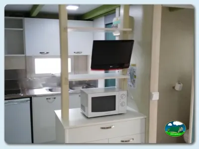 Interior de mobil-home con cocina y televisión del Camping Los Escullos, Almería (Almería)