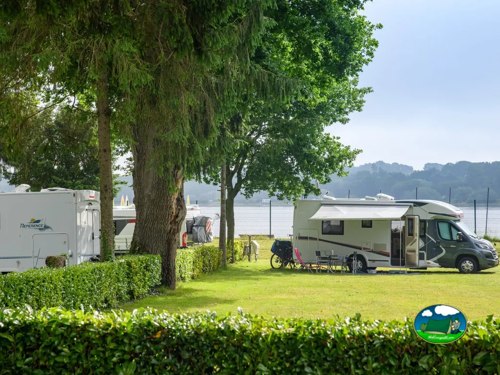 autocaravanas en parcelas junto al lago entre árboles en Taupont