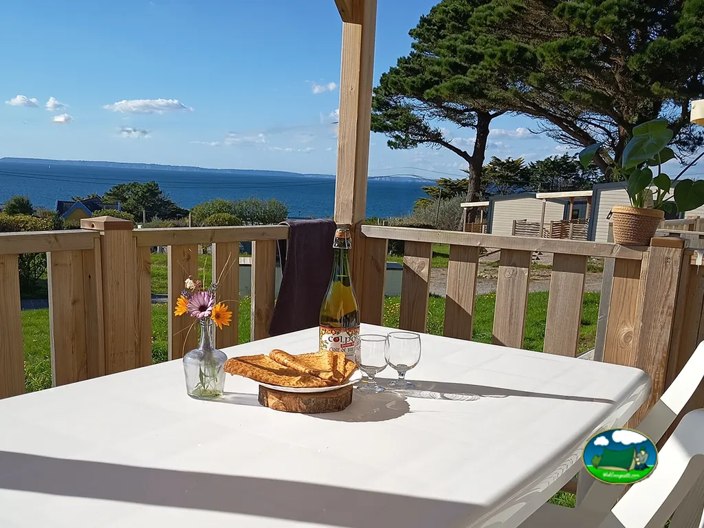 mesa de terraza con crepes y vistas al mar sobre el camping en Plonévez-Porzay