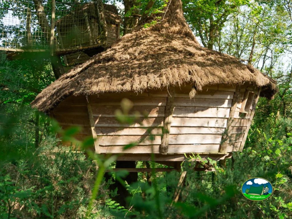 cabaña elevada con tejado de paja entre los árboles en el camping de Nivillac
