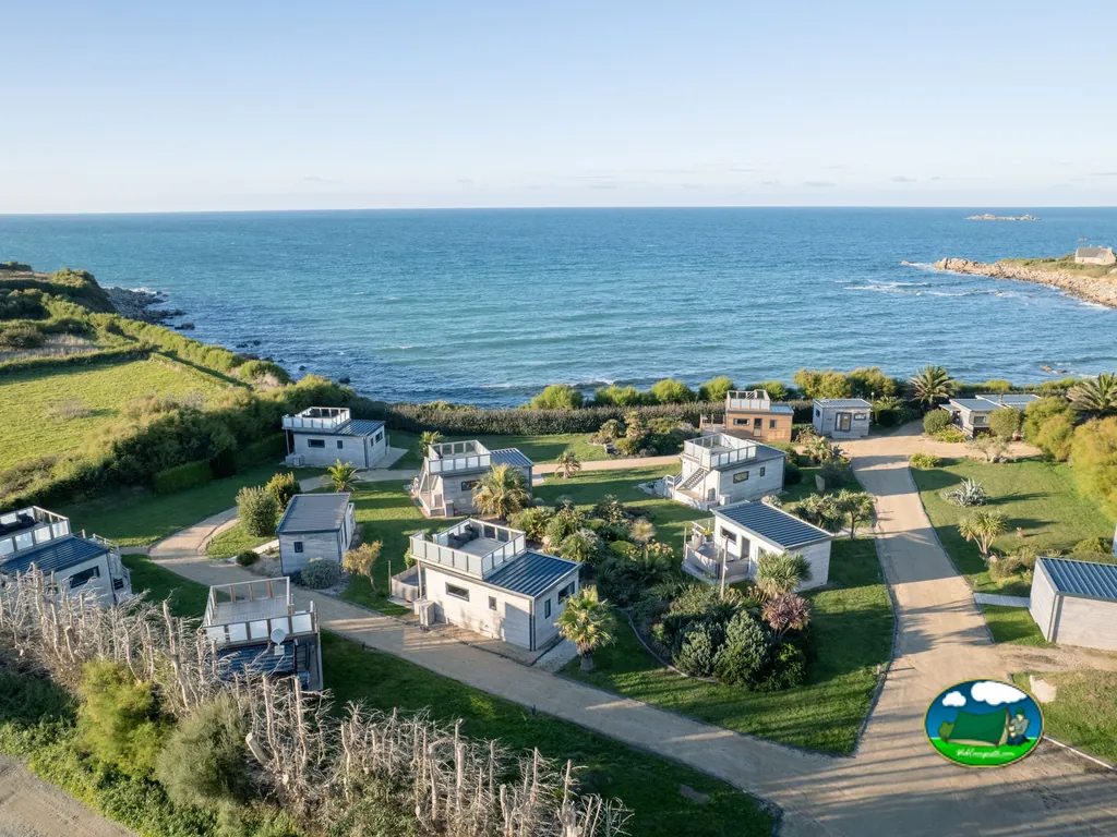vista aérea de cabañas cúbicas modernas con terraza junto al mar en Sibiril
