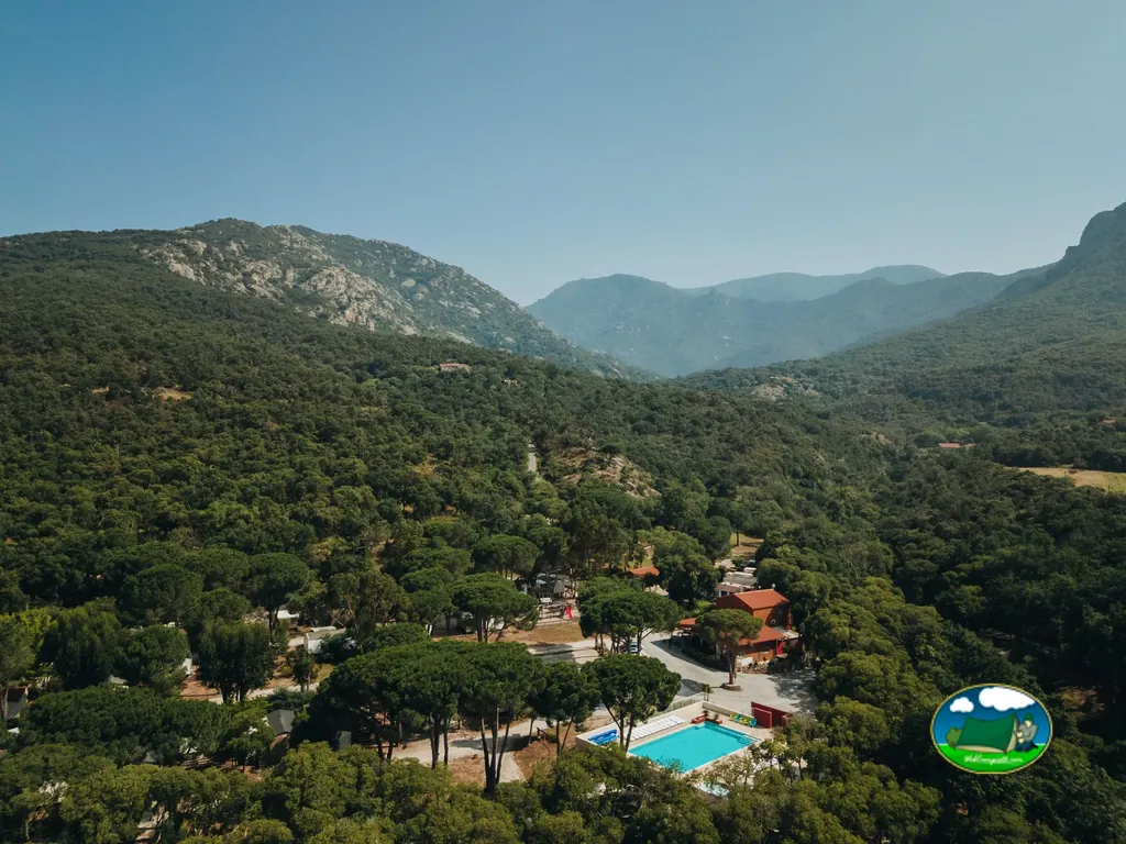 vista aérea del camping con piscina rodeado de montañas boscosas en Argelès-sur-Mer