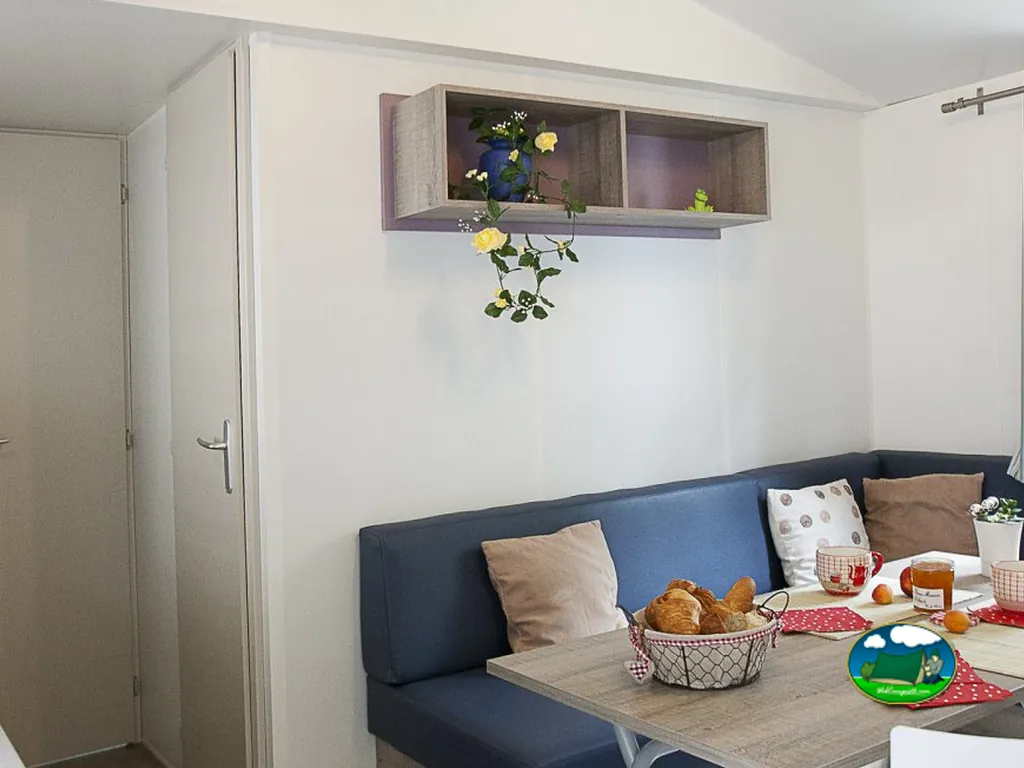 interior de un mobile home con salón comedor decorado y cesta de pan en la mesa