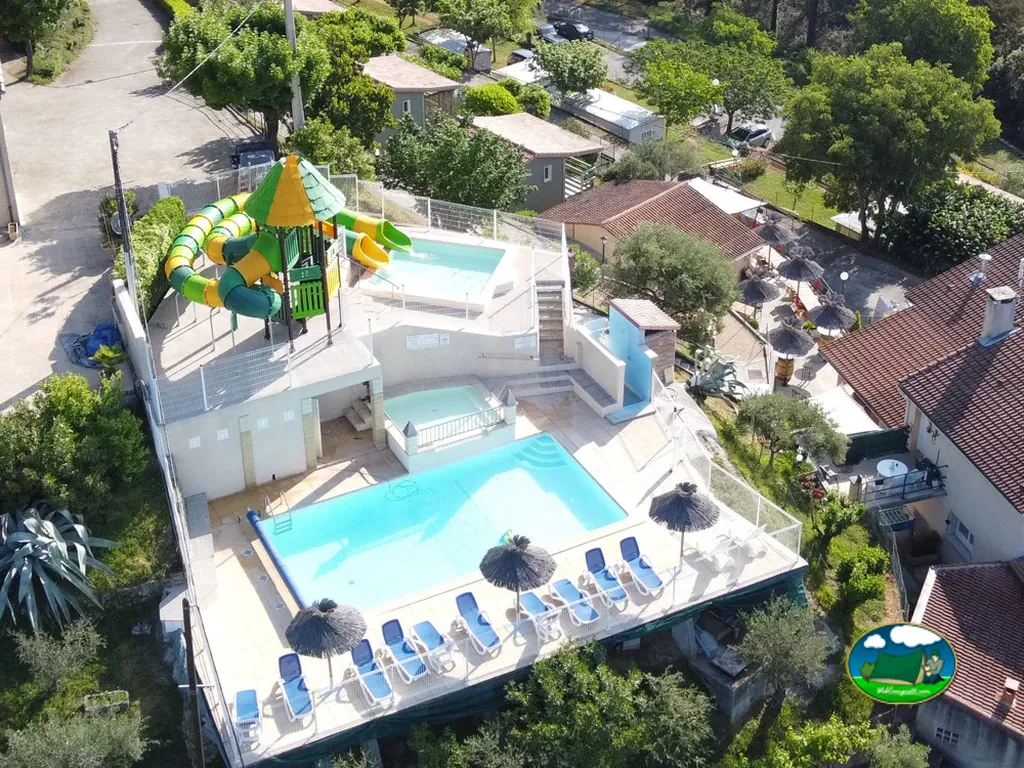 vista aérea de la piscina del camping con tobogán acuático y zona de tumbonas