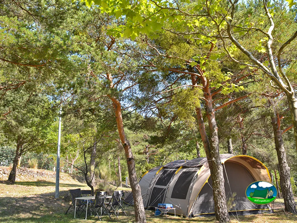 tienda de campaña entre pinos con mesa y sillas de picnic en La Roque-Esclapon