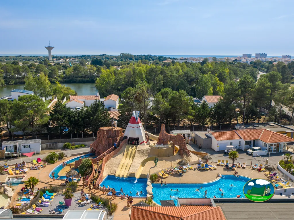 vista aérea de la piscina con tobogán temático del oeste y torre de agua al fondo del camping