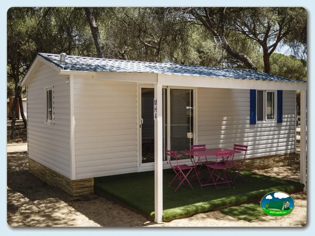 Mobil-home con terraza y zona de sombra bajo árboles del Camping Giralda, Isla Cristina (Huelva)