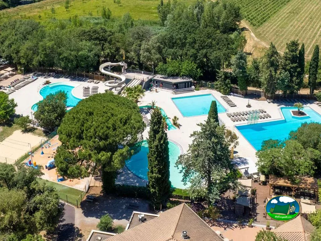 vista aérea de la piscina con tobogán, zona infantil y pista deportiva del camping