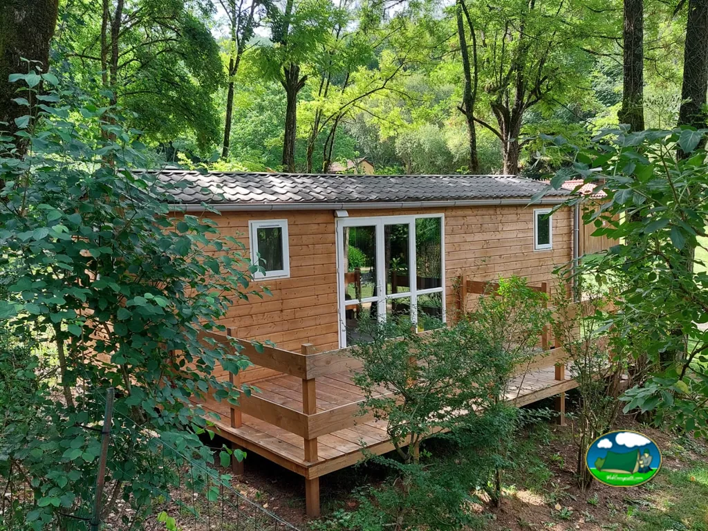 chalet de madera con terraza rodeado de bosque en Tursac