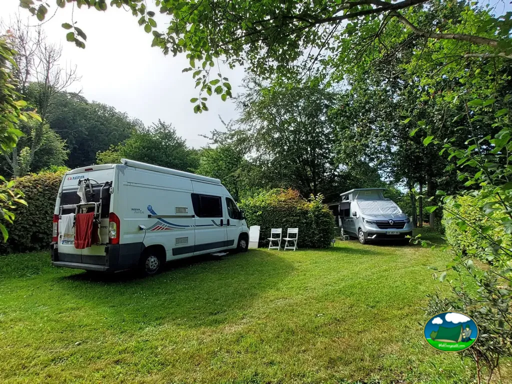 furgonetas camper aparcadas en una parcela de césped bajo los árboles en Saint-Jean-du-Doigt