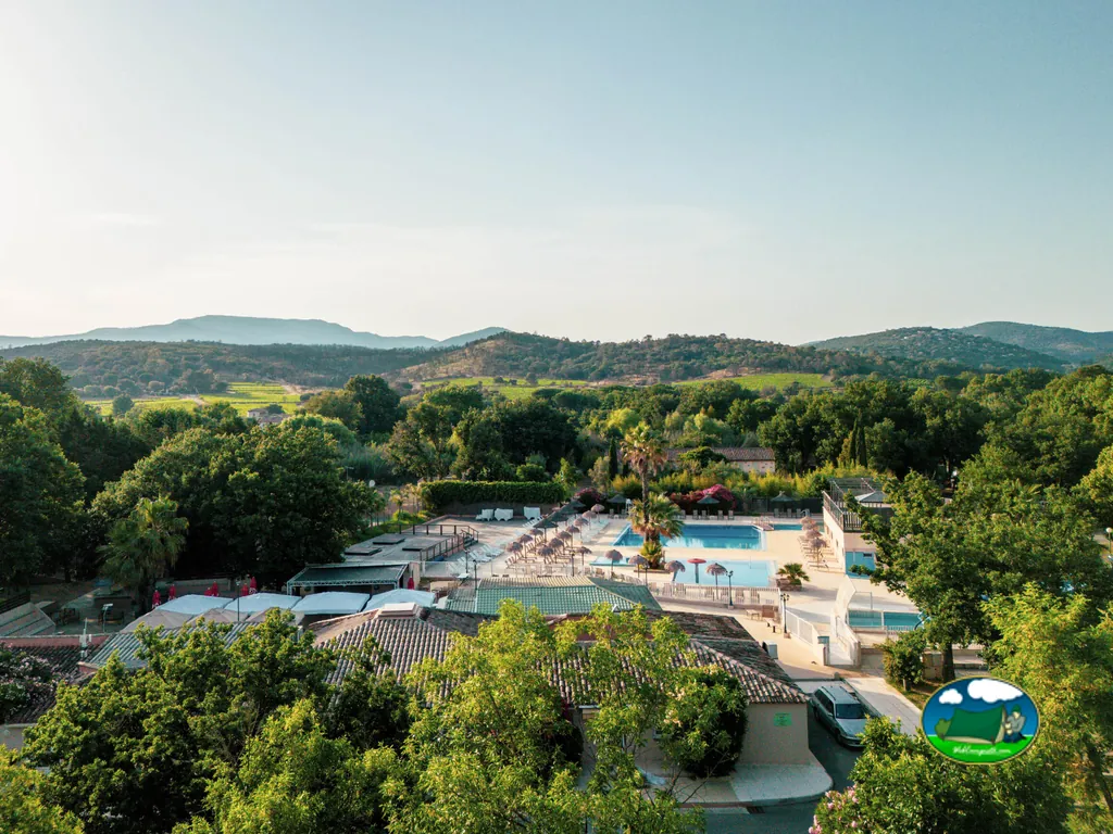 vista aérea al atardecer de la piscina del camping entre colinas en Cogolin