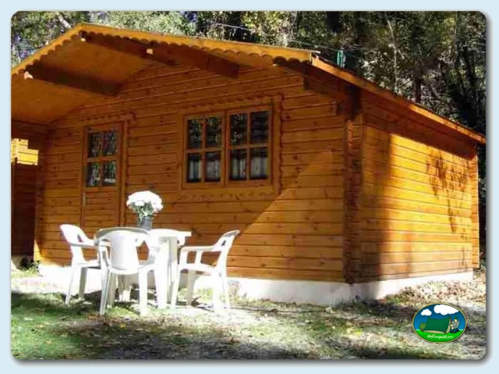 Cabaña de madera con terraza y mobiliario del Camping El Cortijillo, Castril (Granada)