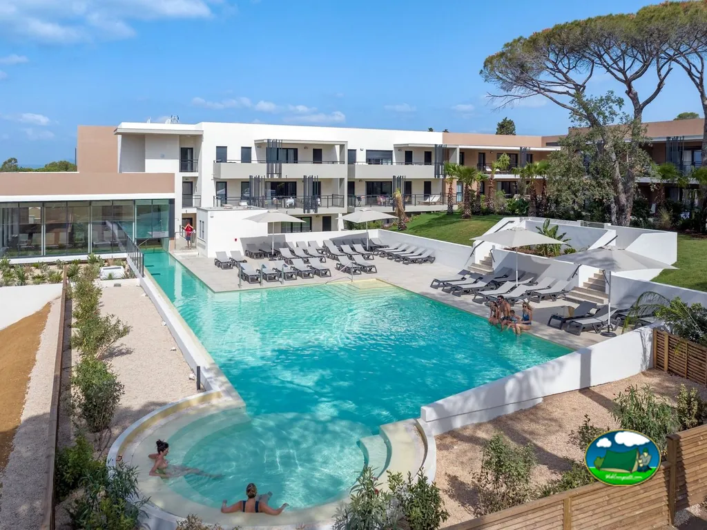 piscina rectangular con tumbonas, jacuzzi y edificios modernos del camping en Saint-Raphaël