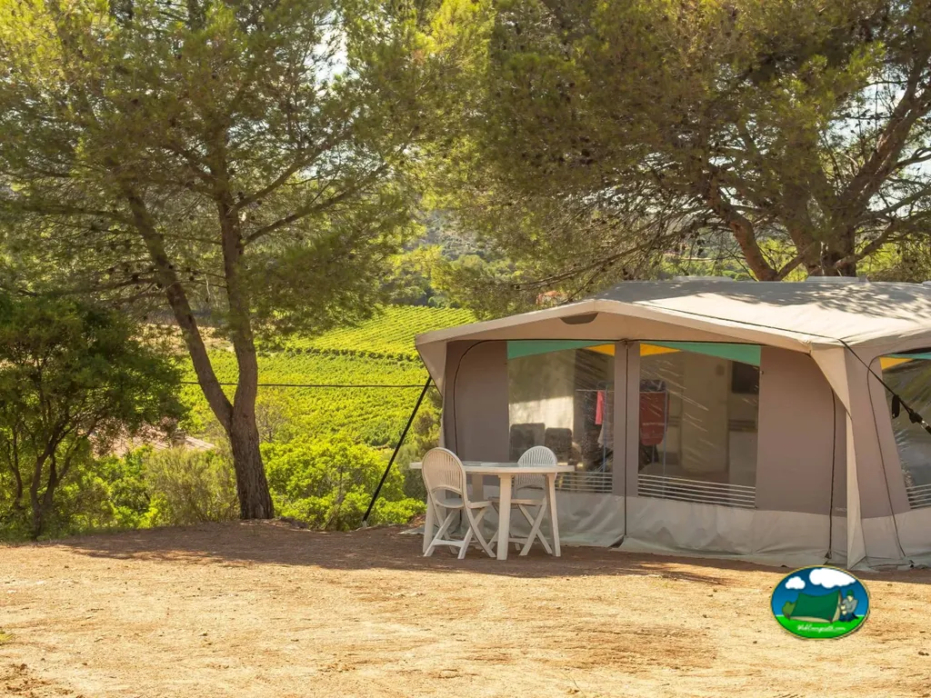 tienda de glamping con mesa exterior frente a un viñedo en el camping de Bormes-les-Mimosas