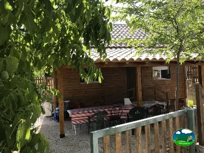 Cabaña de madera con terraza y sombrilla del Camping Las Nogueras de Nerpio, Nerpio (Albacete)