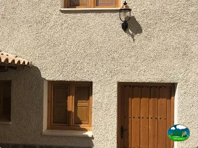 Fachada de cabaña con puertas de madera del Camping Las Nogueras de Nerpio, Nerpio (Albacete)