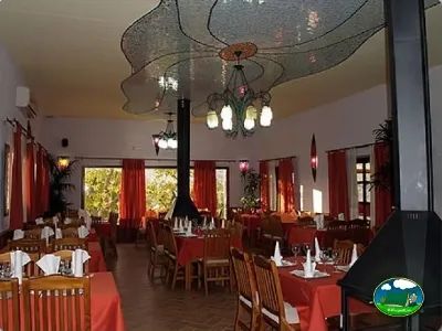 Restaurante interior con chimenea y mesas preparadas del Camping Las Nogueras de Nerpio, Nerpio (Albacete)