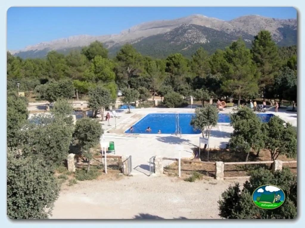 Piscina con vistas a la montaña, rodeada de pinos del Camping Sierra de María, María (Almería)