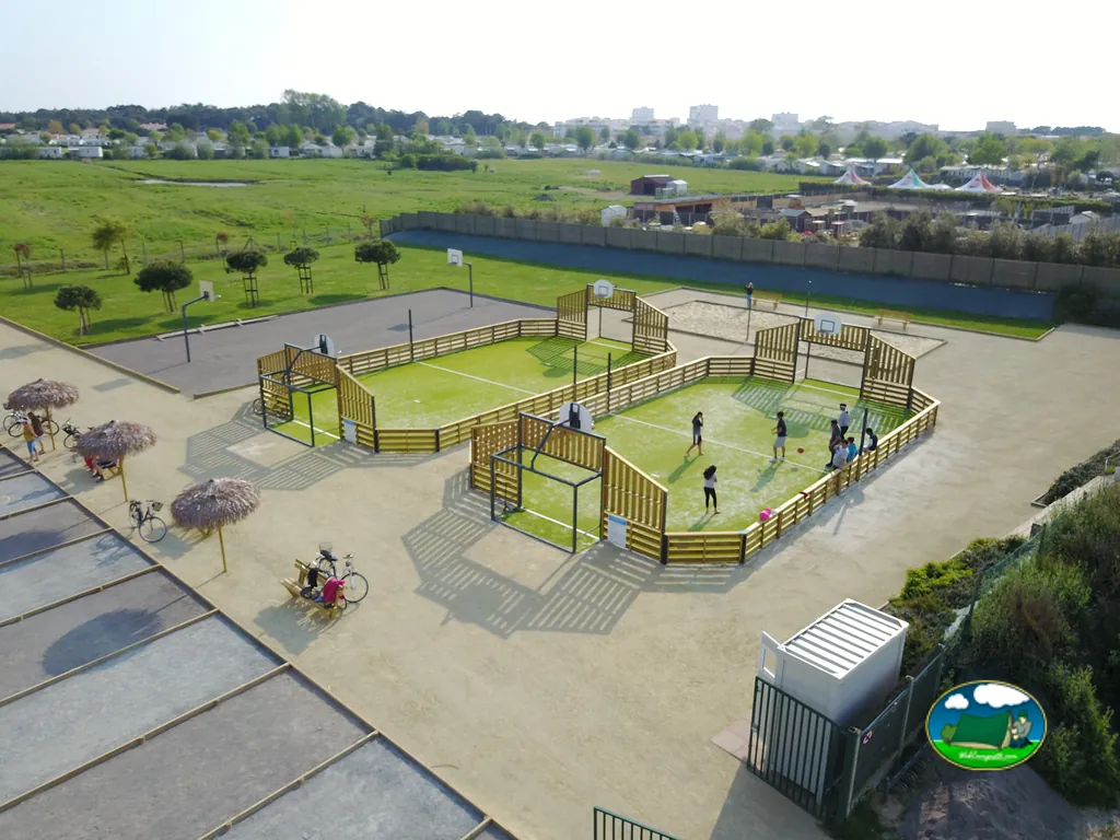 vista aérea de una pista multideporte con jóvenes jugando junto a bicicletas aparcadas