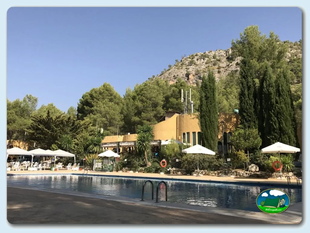 Piscina con vistas a la montaña y edificio principal del Camping La Puerta, Moratalla (Murcia)