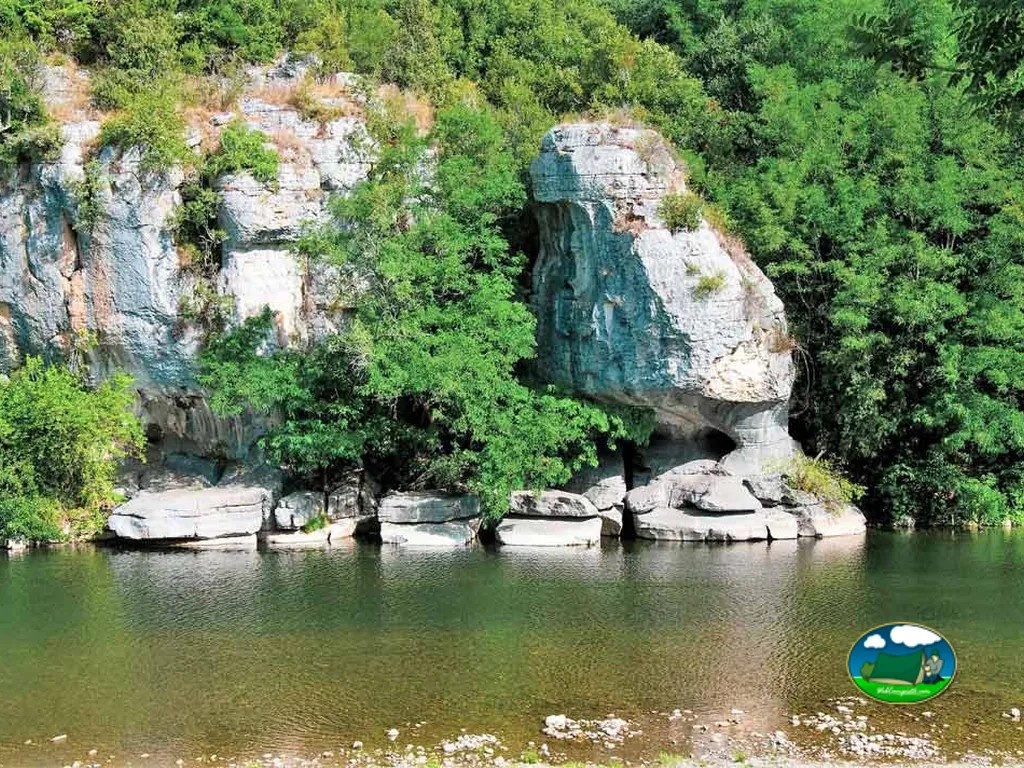 paredón rocoso cubierto de vegetación junto al río del camping en Berrias-et-Casteljau