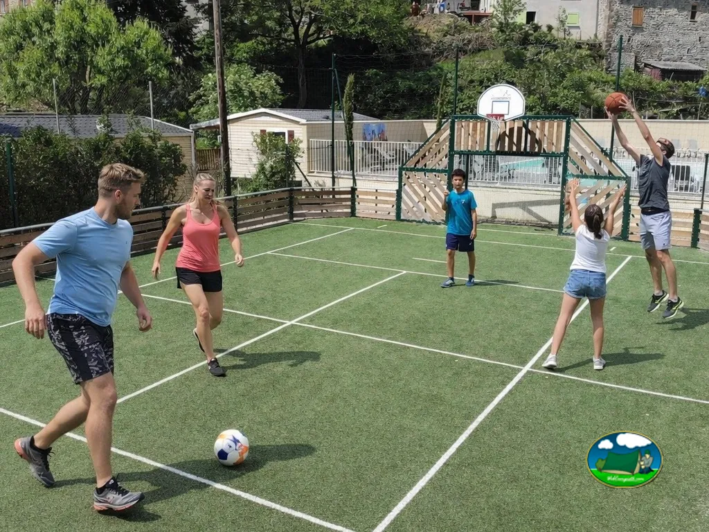 familia jugando al fútbol y al baloncesto en la pista polideportiva del camping en Lamastre