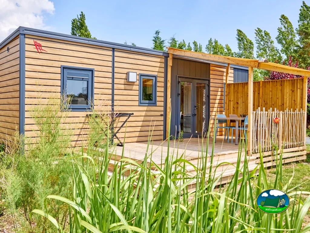 bungalow de madera con terraza y vegetación de juncos en primer plano en La Tranche-sur-Mer