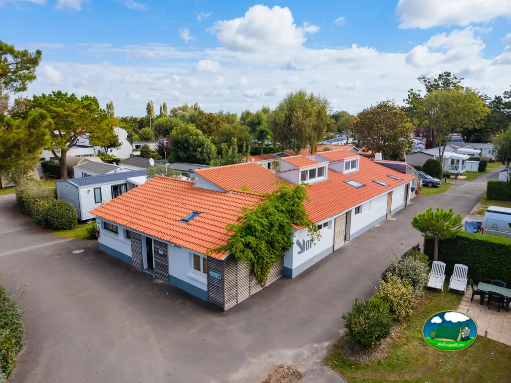 vista aérea del edificio principal de tejado naranja rodeado de bungalós en el camping de Saint-Jean-de-Monts