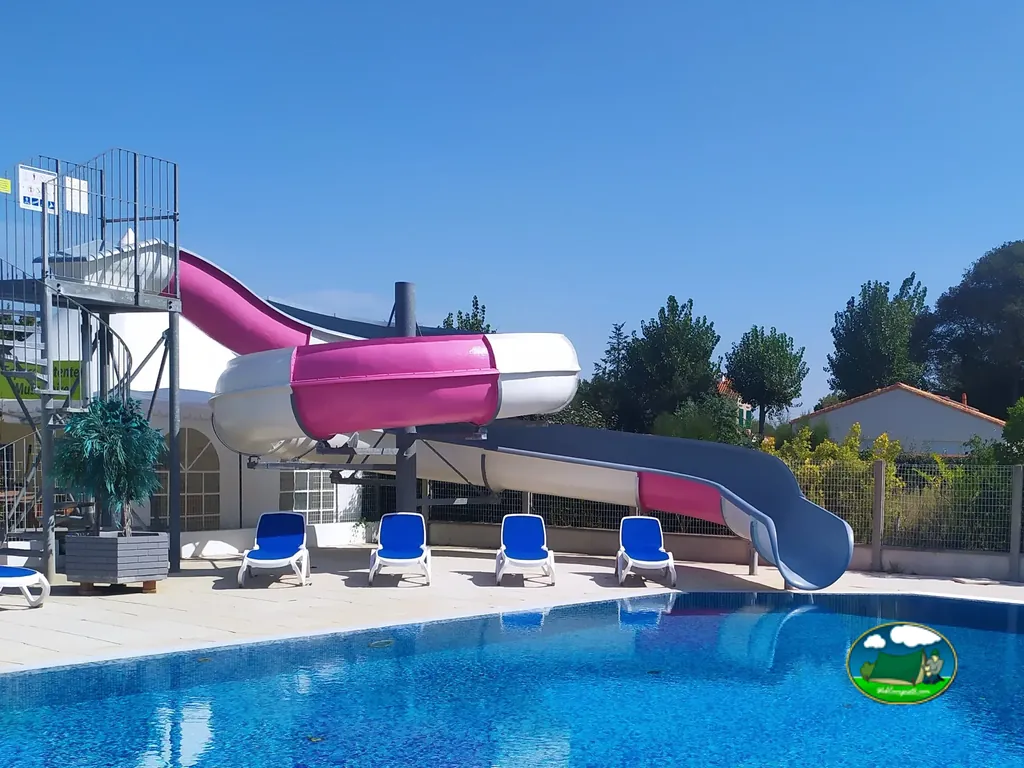 tobogán acuático rosa y blanco junto a la piscina exterior