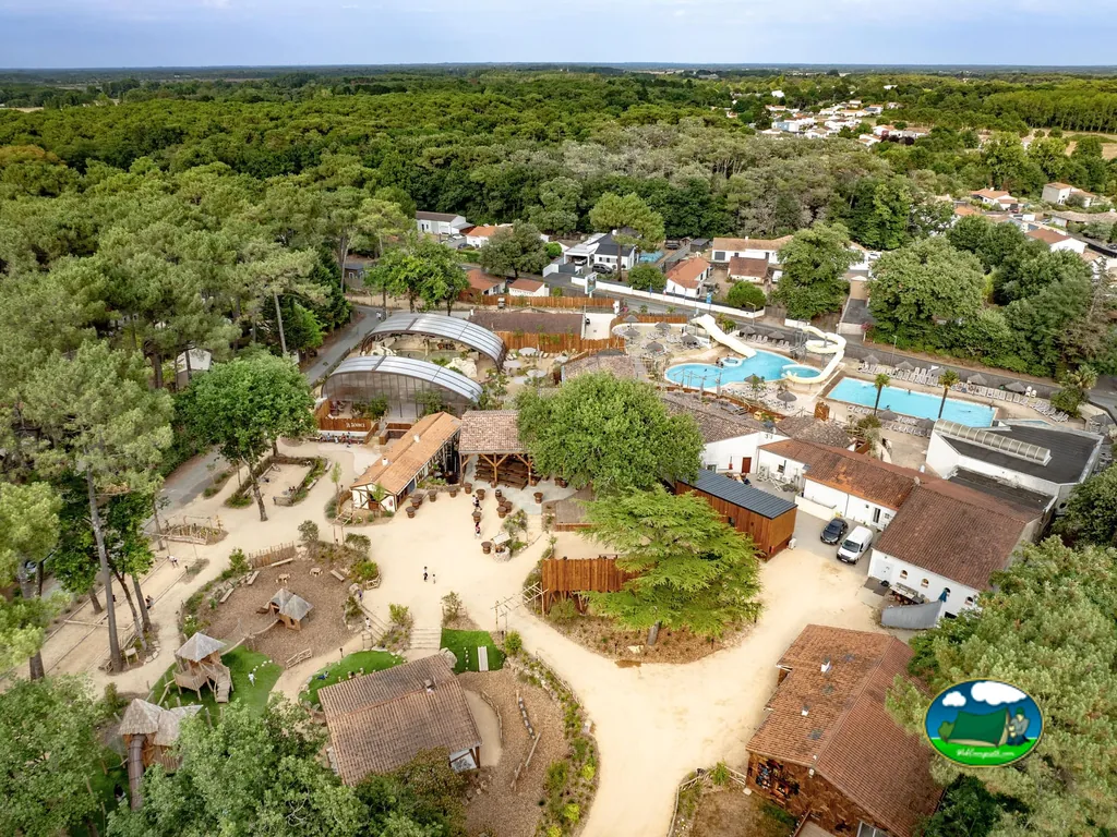 vista aérea del camping con piscinas cubiertas, zona infantil y mobil homes entre pinos en Saint-Hilaire-de-Riez